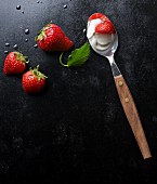 Fresh strawberries and yoghurt on a spoon