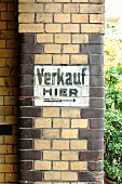 Altes aufgemaltes Schild auf einer Backsteinfassade