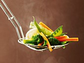 Cooked vegetables on a draining spoon