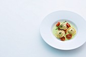 Lamb ravioli with tomatoes on herb foam