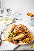 Spicy roast chicken with lemon, garlic and herbs on a table