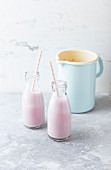 Pomegranate and almond milk smoothies in glass bottles