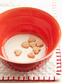 Heart-shaped biscuits in a bowl of milk