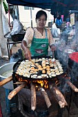 A woman making fritters in a street kitchen (Myanmar, Burma)