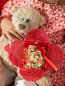 Kind hält Lunchbox mit Zucchini-Tomaten-Risotto