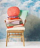 Retro armchair with stack of laundry and pillows