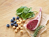 A lamb chop with blueberries, chickpeas, rosemary and spinach