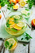 Citrus fruit tea with mint in a glass jug