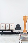 Black classic chair next to console table and framed pictures in minimalist, retro interior