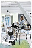 Outlines drawn on photo of painter at side table and pots of paint in artist's studio