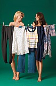 Two women behind a washing line hung with clothes