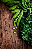 Fresh kale and peas on a wooden surface