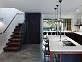 Counter with marble worksurface and staircase in open-plan kitchen