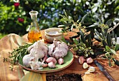 Knoblauch, frische Kräuter, Salz und Olivenöl auf Gartentisch