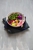 Salad with fried tofu, radishes, red cabbage, pomegranate seeds, avocado, cress and cashew nuts