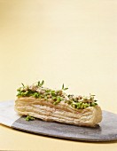 A puff pastry slice with pea cream, crab meat, horseradish and pea sprouts