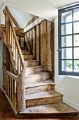 Rustic wooden staircase and lattice window in 18th-century farmhouse