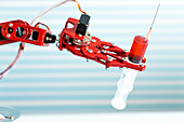 Robotic arm holding medical syringe
