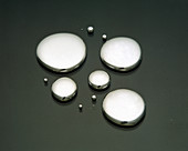 Drops of mercury on a black surface