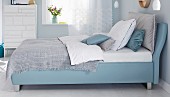 A boxspring bed in a bedroom in blue tones