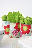 Tin cans covered with floral paper used as cutlery holders