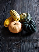 Various types of squash on a grey wooden surface