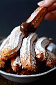 Churros with icing sugar and chocolate sauce