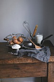 Ingredients and baking utensils for making crêpes on a wooden table