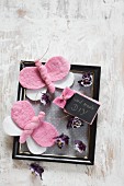 DIY Schildchen und Schmetterlinge aus rosa Filz auf schwarzem Bilderrahmen mit violetten Blüten