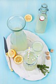 Thyme lemonade in a bottle, a carafe and glasses