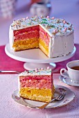 Rainbow cake decorated with sugar pearls, sliced