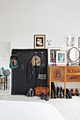 Gerahmte Tafel mit Kleiderhaken und Schuhe unter Schminktisch mit Spiegel