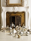 Traditional Christmas decorations in silver and gold in front of fireplace with brass doors
