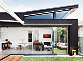 View from the summer garden into the open living space of a modern architect's house