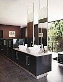 White countertop basins, tall mirrors, bathtub and glass wall in designer bathroom