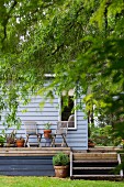 View of terrace with garden chairs in front of wooden house