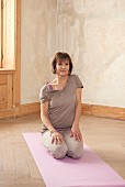 Shoulder raises (yoga) on the mat: sit back on heels, raise shoulder