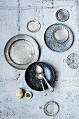 Pewter plates, bowls and spoons on a vintage surface