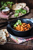Chickpea and spinach curry with fresh coriander and naan bread (India)