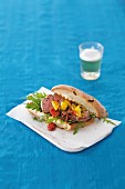 A steak sandwich with braised tomatoes and rocket