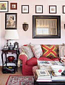 Red sofa, antique side table and gallery of pictures in living area