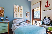 Boy's room with 'skeleton poster' on blue wall and bed with blue and white bedding