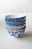 Four blue and white patterned bowls on a white surface