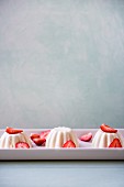 Panna Cotta mit frischen Erdbeeren auf länglicher Servierplatte