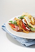 Pancakes with beefsteak, tomatoes, onion and rocket