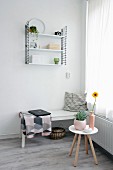 White wooden bench, laptop on blanket and classic String shelves in corner
