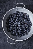 Freshly washed blueberries in an aluminium colander