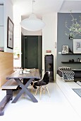 Rustikaler Holztisch mit Sitzbank und Klassikerstühlen in Wohnraum mit Podest