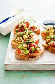Bruschetta topped with avocado and tomatoes
