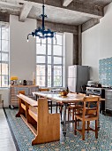 Ornate tiles and eclectic furnishings in open-plan kitchen with tall industrial windows